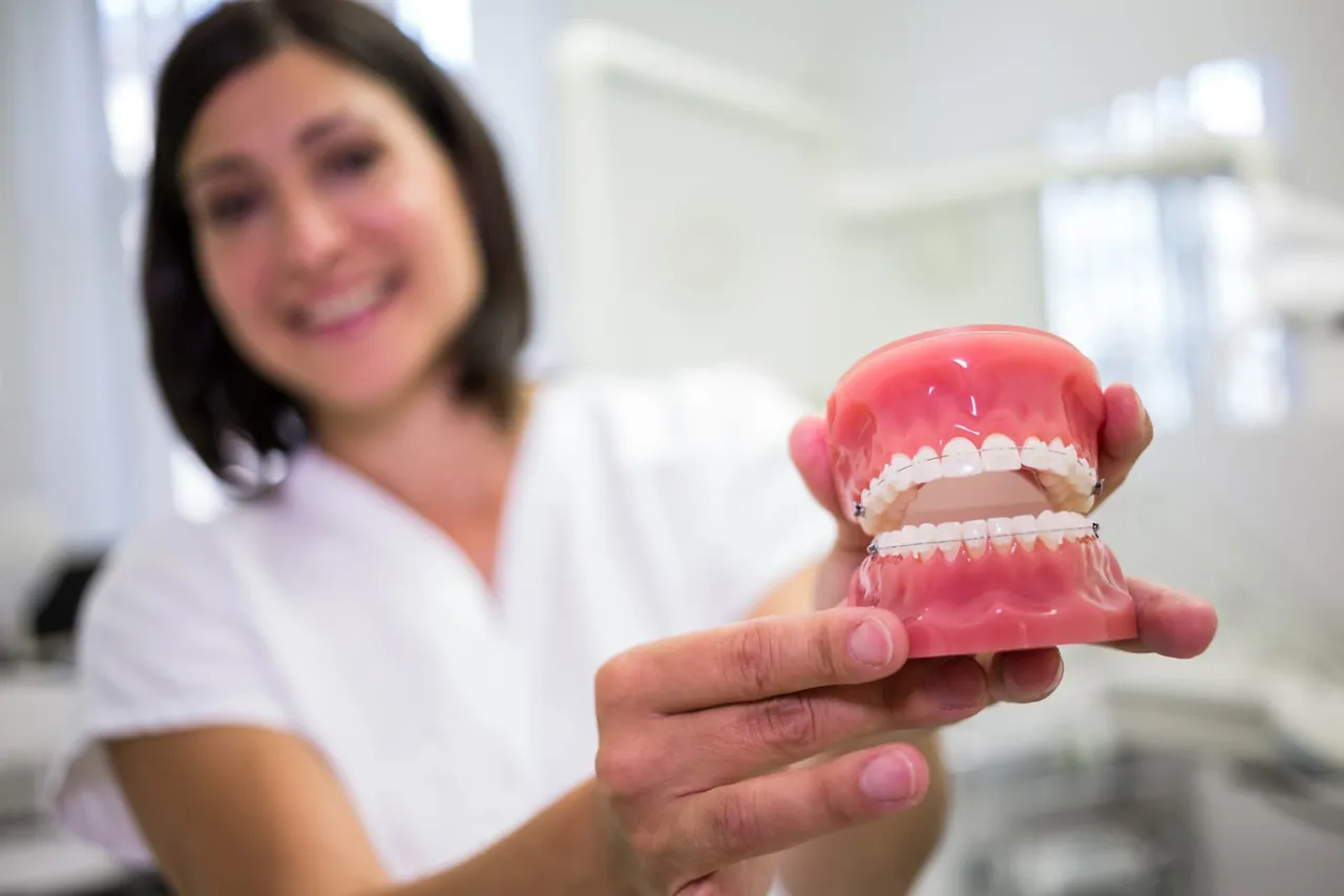 Dental professional holding a denture model