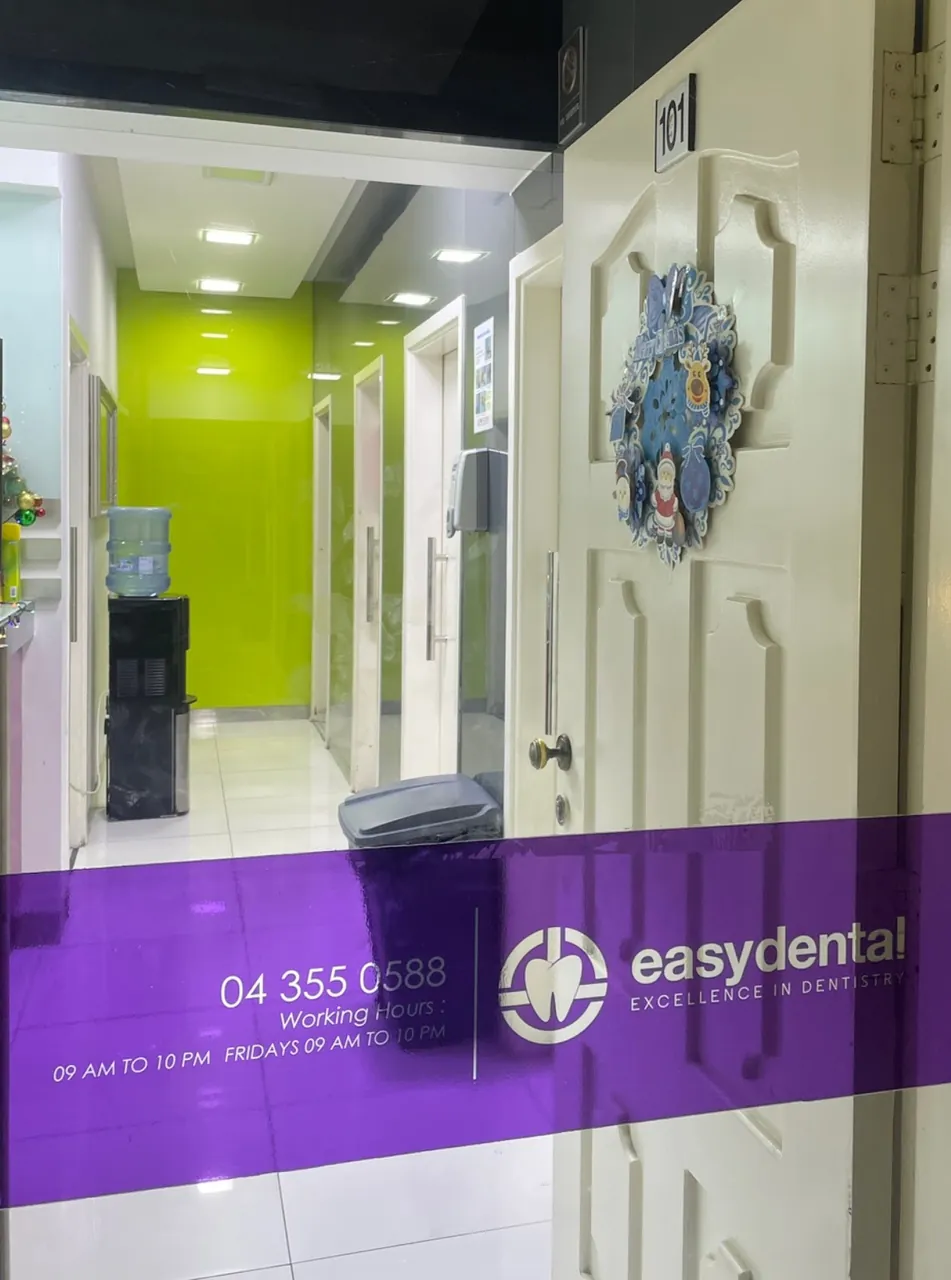 Glass entrance door with the Easy Dental logo and phone number, Al Satwa