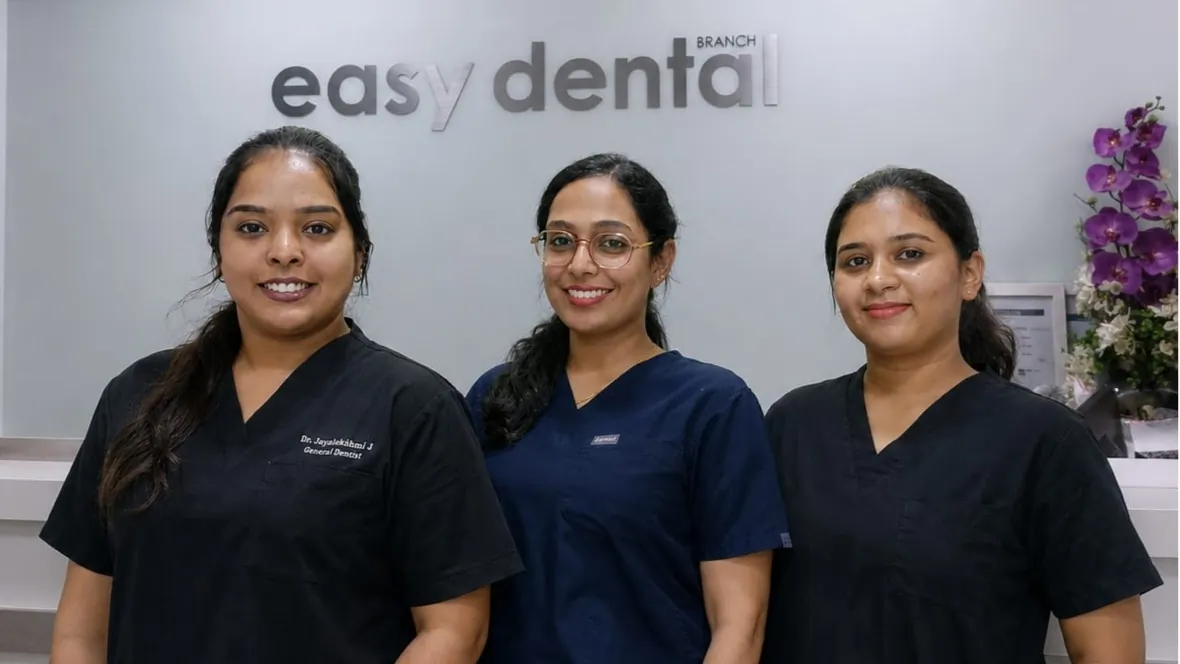 Three team members in scrubs in front of the Easy Dental sign, Al Satwa