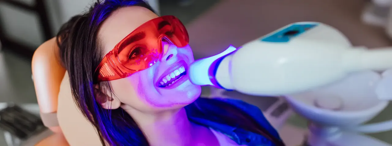 Patient having in-chair teeth whitening with a whitening light