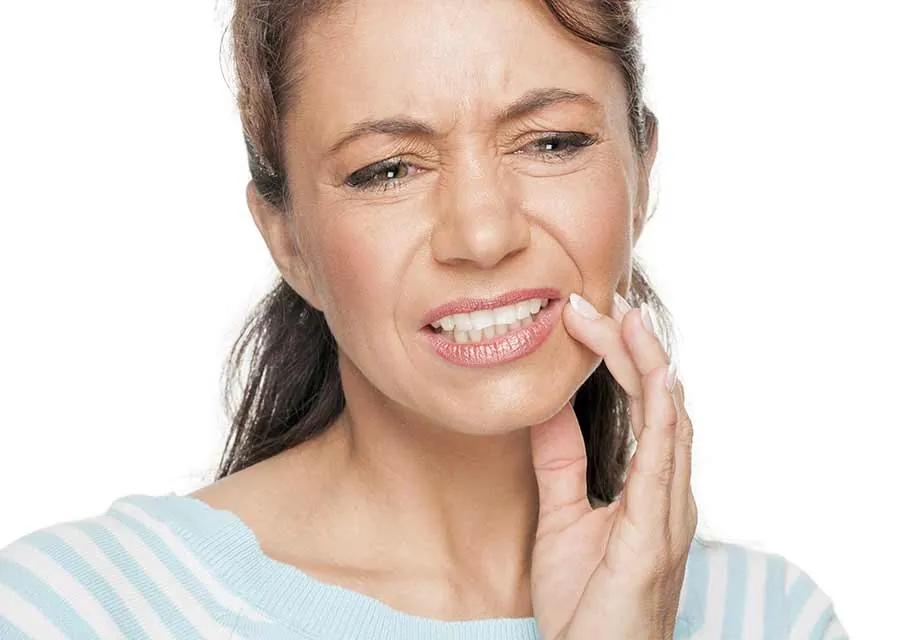 Woman holding her cheek because of tooth pain